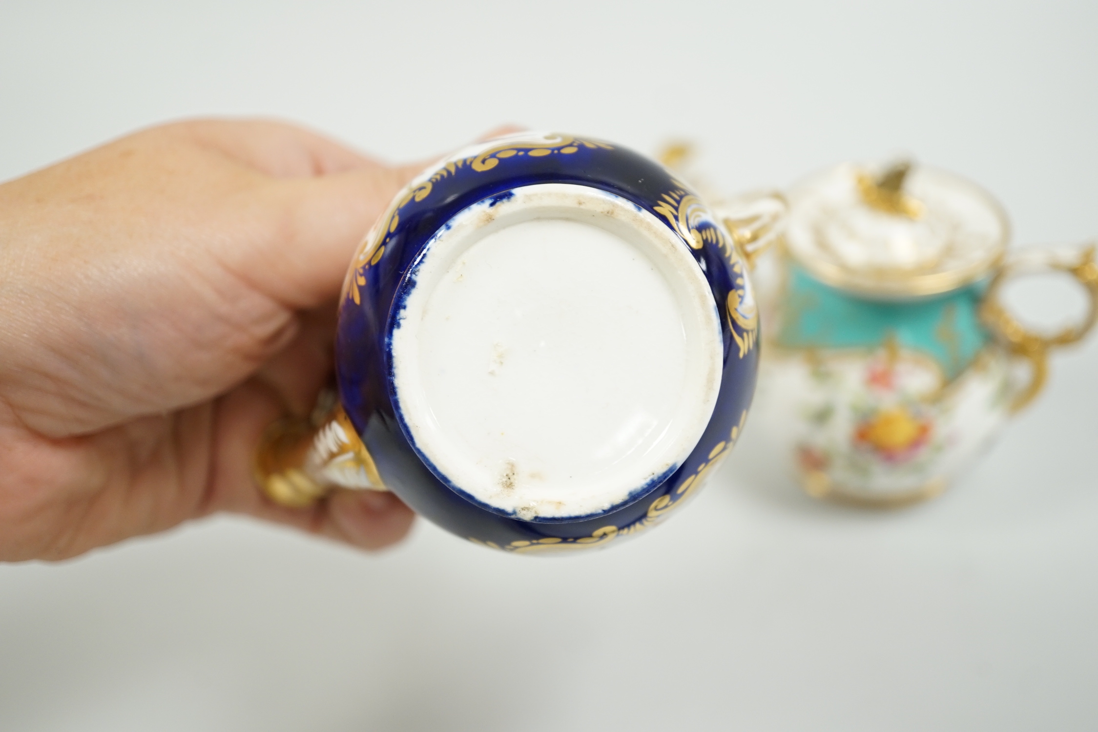 Toy porcelain. Two English rosewater sprinklers, c.1820, possibly Coalport, each modelled in the form of a watering can, tallest 9cm high